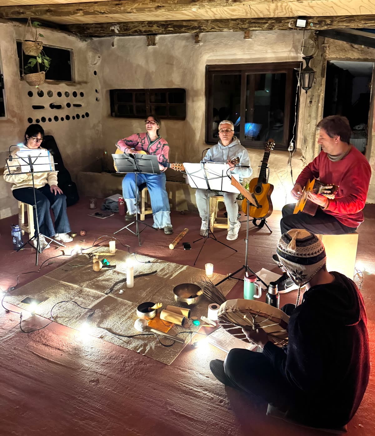 El ensamble de Movimiento Mainumby tocando en círculo, con velas y cuencos en el centro